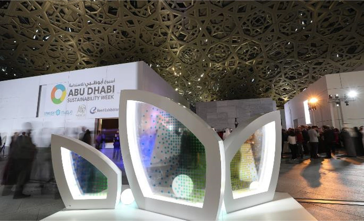 Evolution Scenic plywood leaf structures creating an illuminated reception environment in Abu Dhabi.