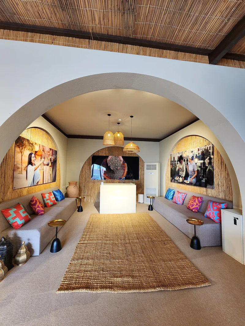 Evolution Scenic arched scenic lounge interior with barasti backdrops, integrated seating and wall-mounted displays.