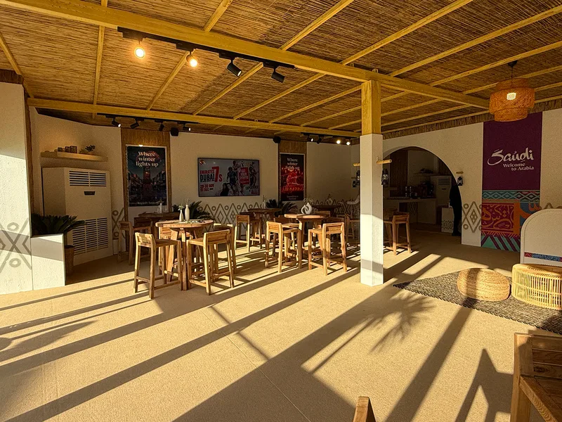 Custom aluminium-framed ceiling finished with barasti poles and integrated scenic lighting.
