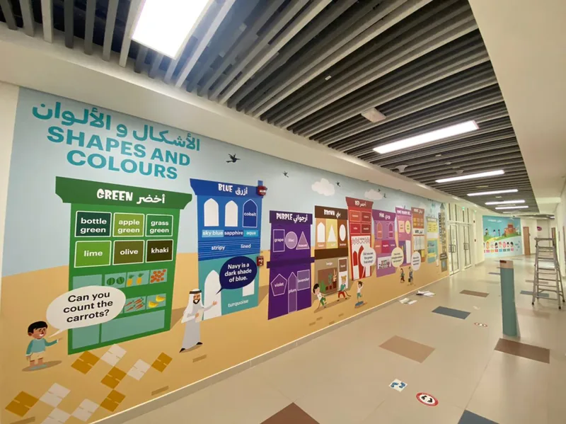 Bilingual educational wall graphics installed throughout NCE school circulation spaces.