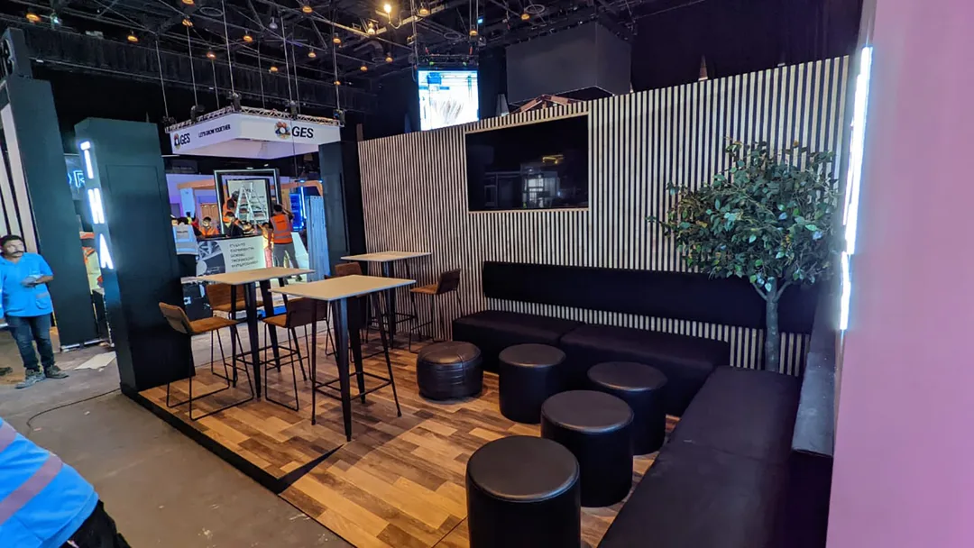 THA exhibition seating backdrop with birch plywood slats and integrated television screen.