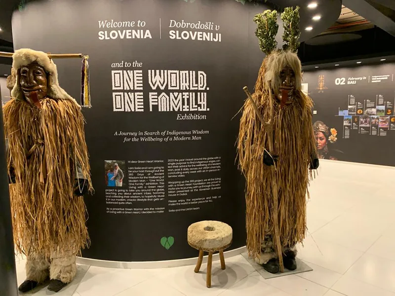 Curved black exhibition wall framing traditional costume displays and entrance graphics.