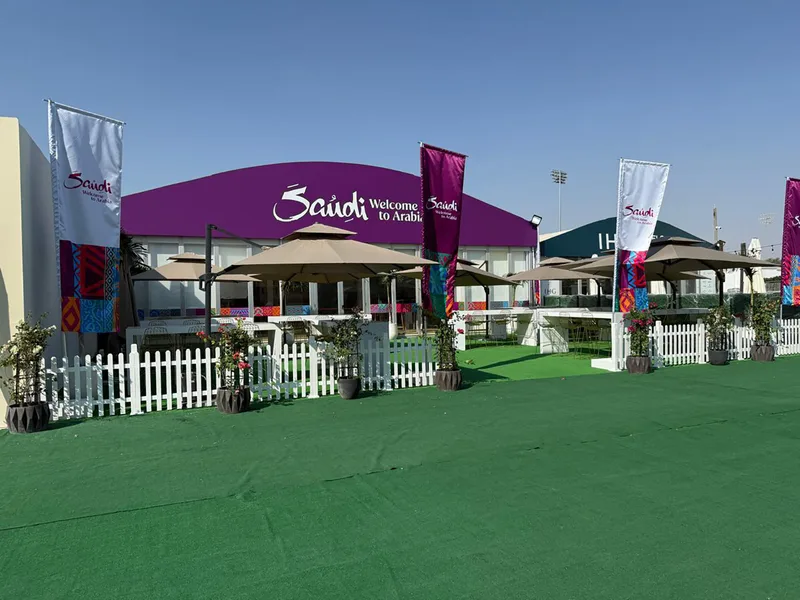 Evolution Scenic branded flagpoles and planted features defining the outdoor seating area.