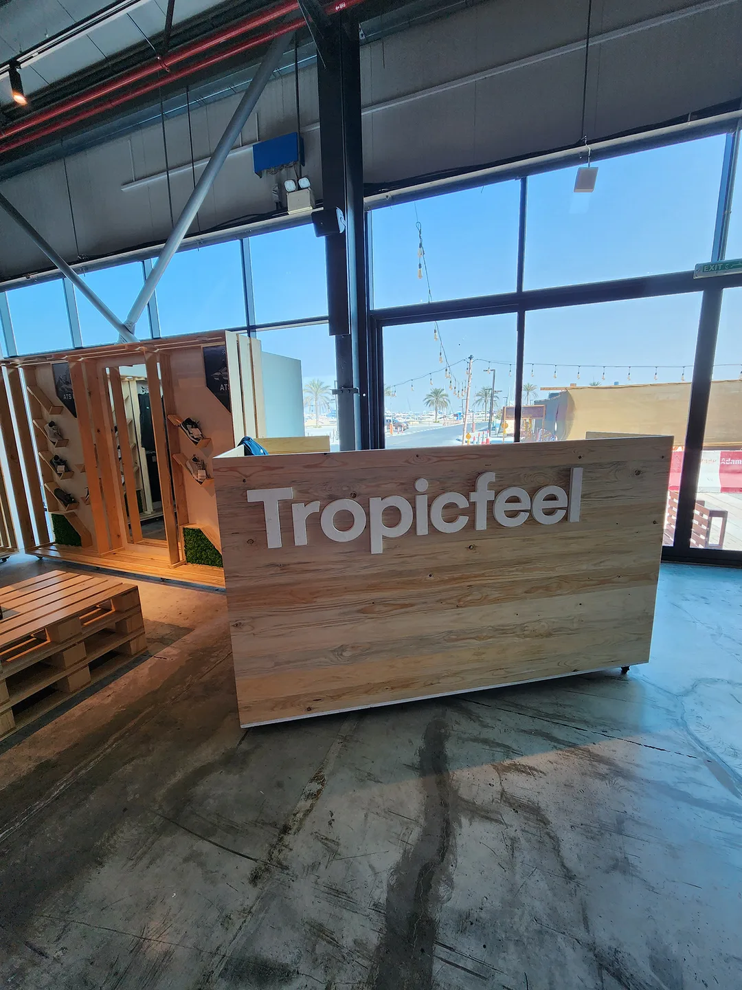 Custom information desk with painted Tropicfeel logo and concealed internal storage.