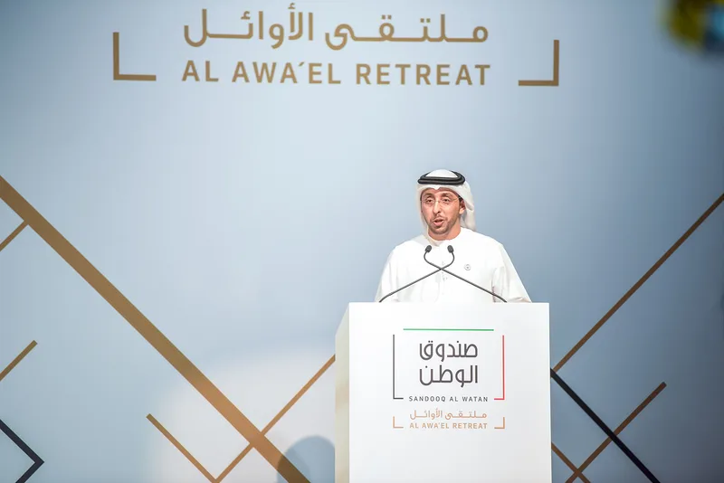 Branded lectern positioned against the geometric Al Awa’el Retreat scenic backdrop.