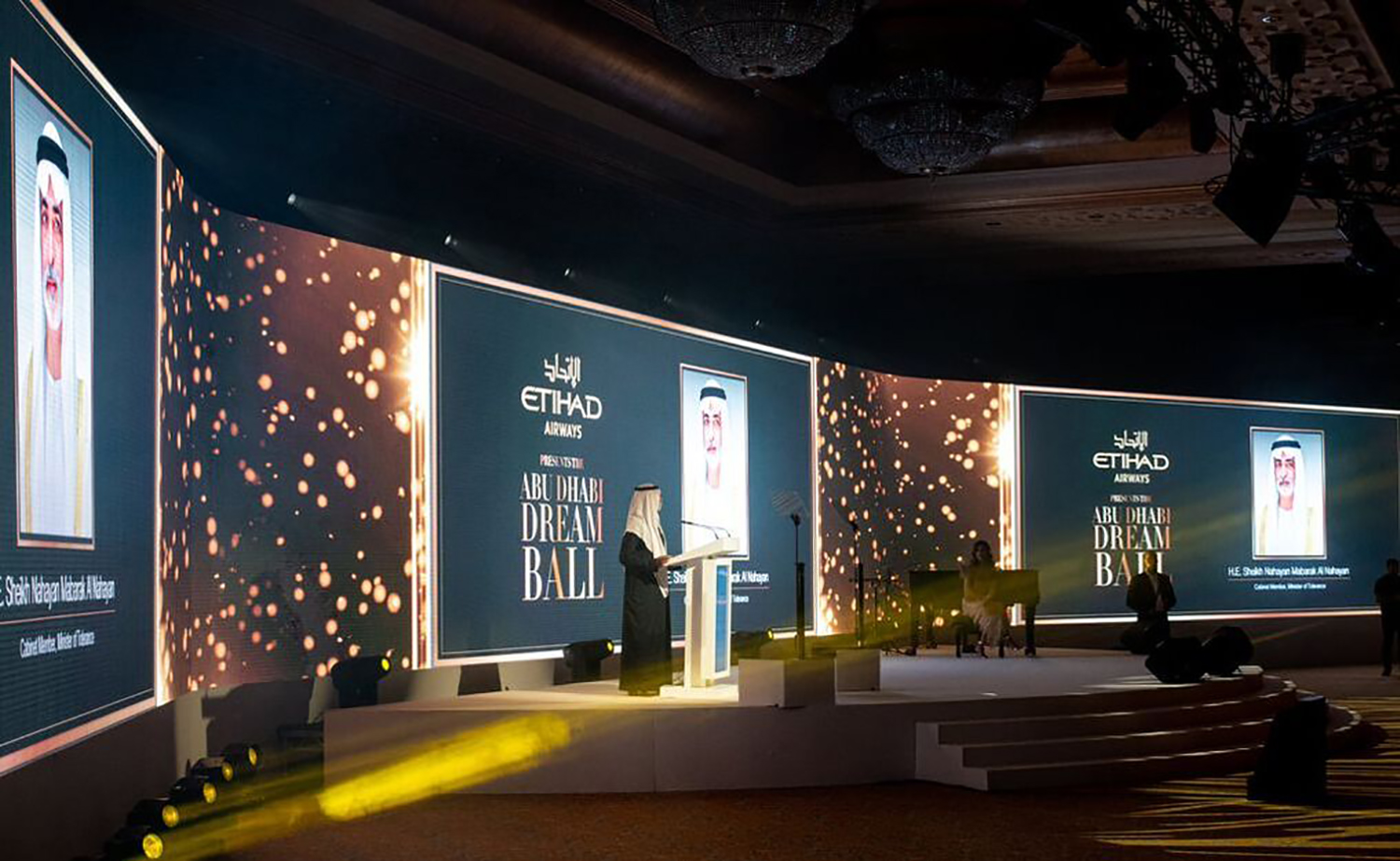 Wide scenic stage composition with framed visual screens and integrated Dream Ball branding.