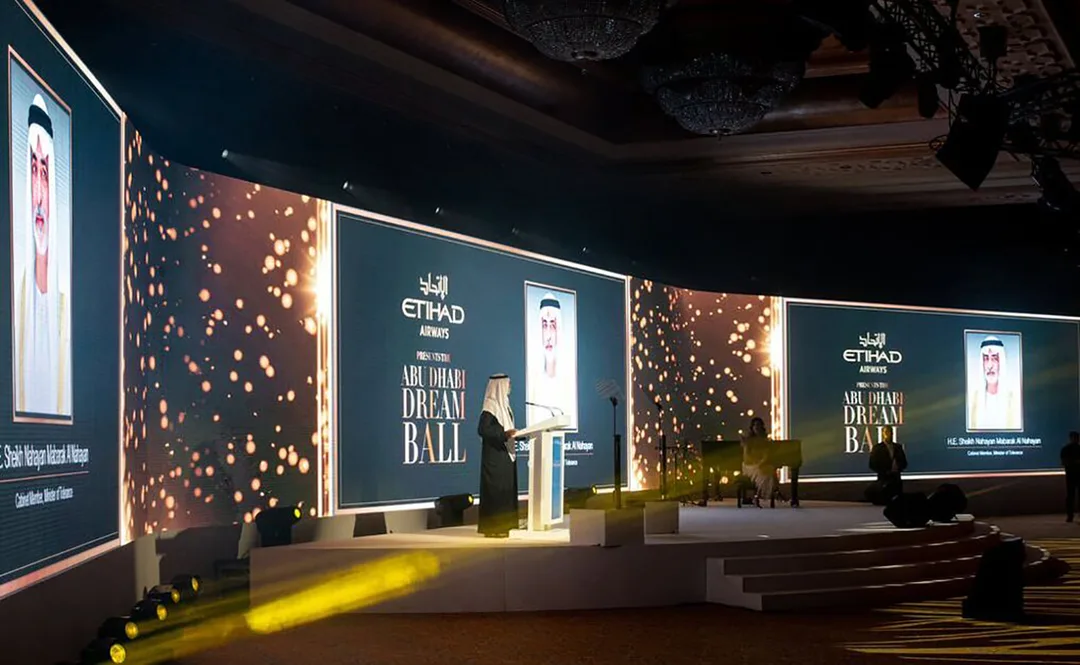 Wide scenic stage composition with framed visual screens and integrated Dream Ball branding.