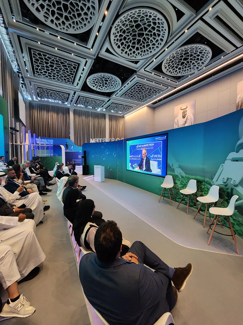 Curved exhibition environment fabricated around embedded LED screens, carpet flooring and branded wall graphics.