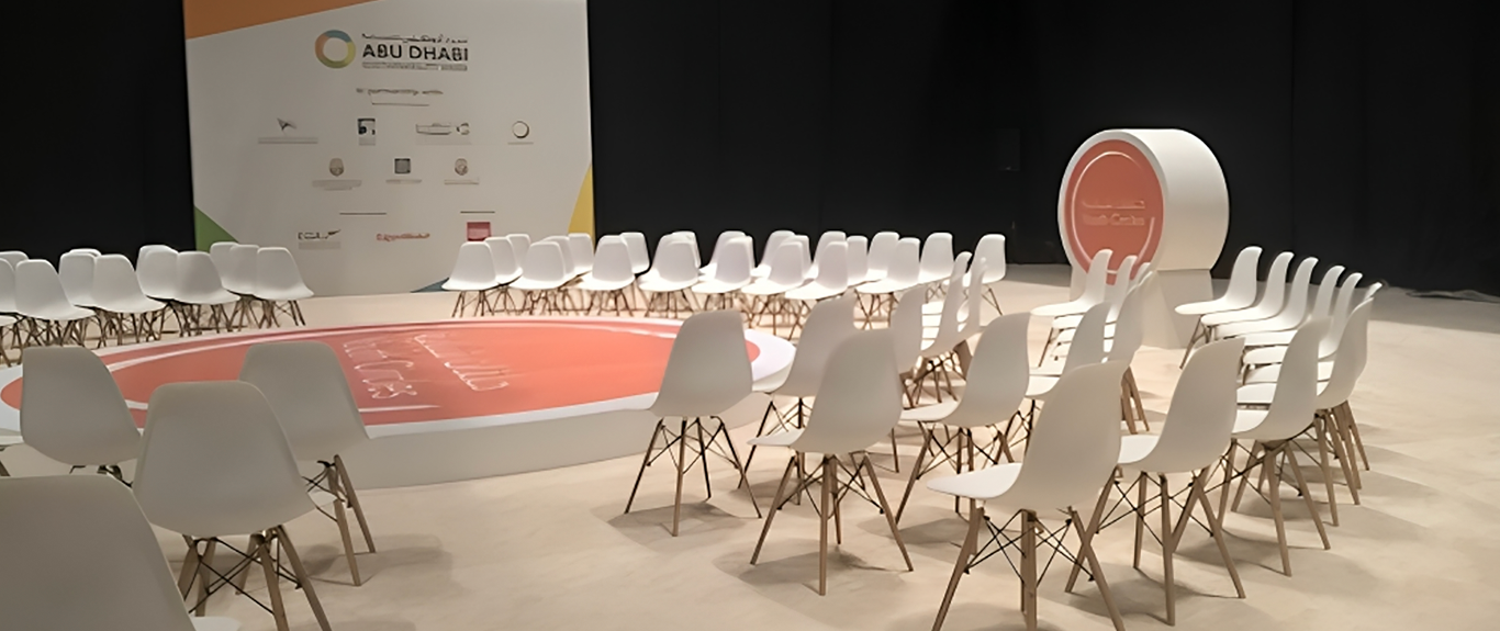 Evolution Scenic circular Youth Circle stage with orange branded floor graphic in Abu Dhabi.
