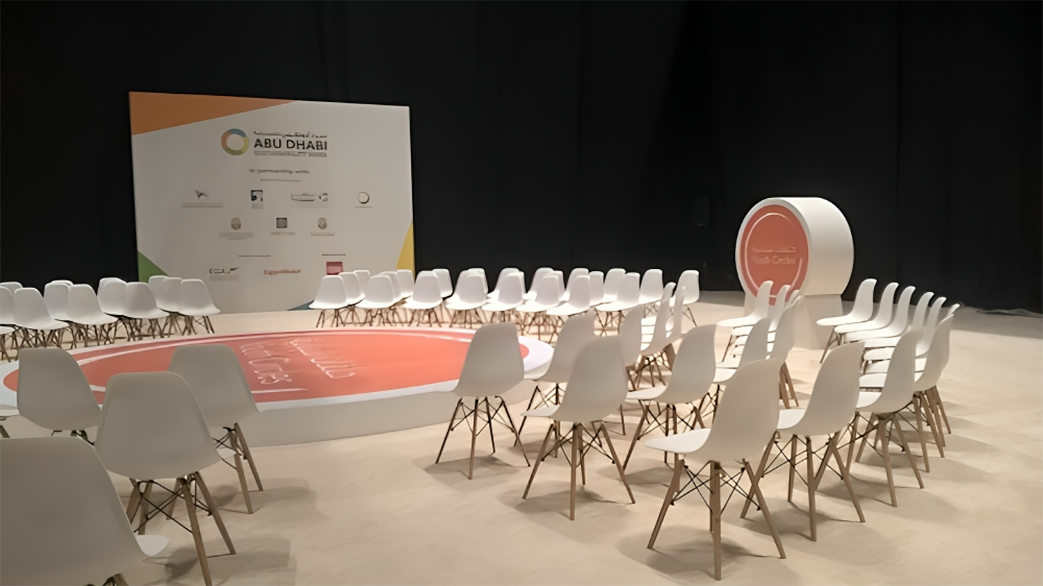Wide-angle view of the circular stage, logo feature and secondary branding wall.