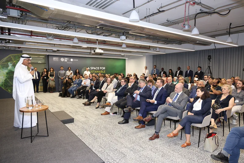 Carpeted stage, branded walling and movable screens forming the Dubai Climate Hub environment.
