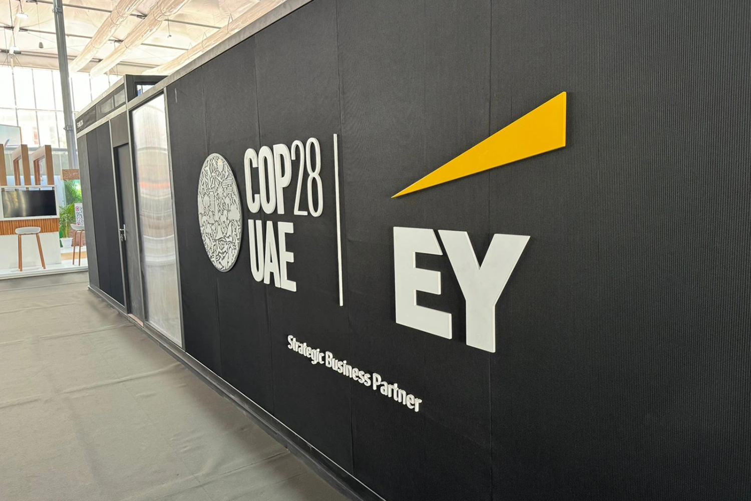Matte black scenic wall with COP28 UAE and EY graphics fabricated for the Dubai exhibition environment.