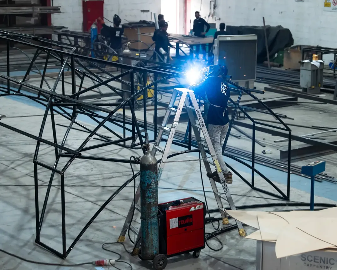 Evolution Scenic structural framework and scenic cladding during fabrication of a large temporary installation.