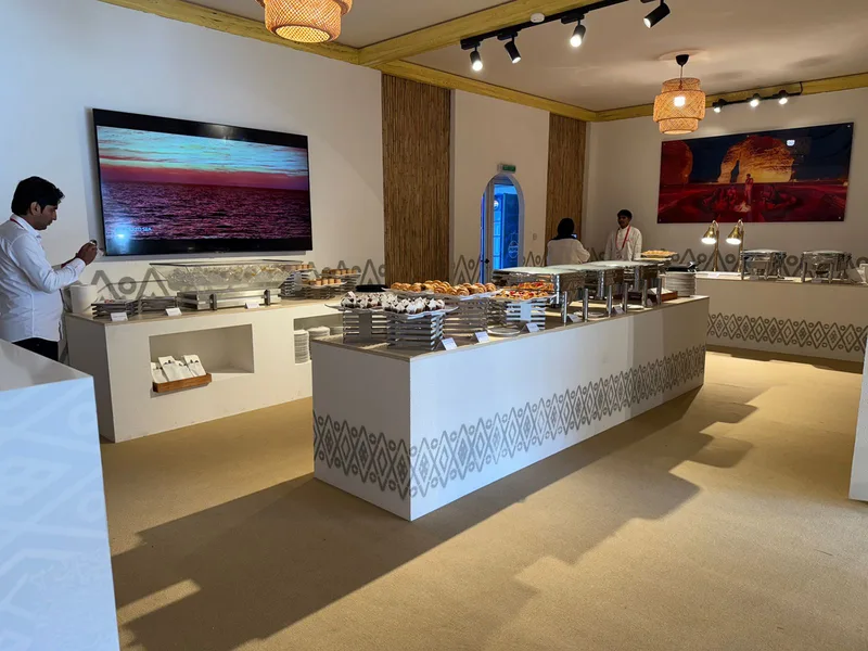 Four custom buffet counters integrated into the branded Visit Saudi scenic interior.