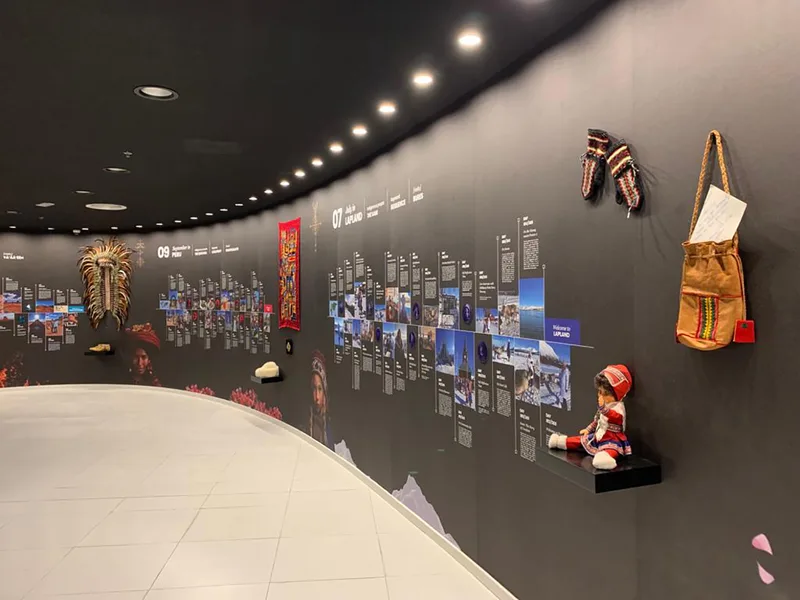 Custom black display plinths arranged against curved interpretive timeline walls.