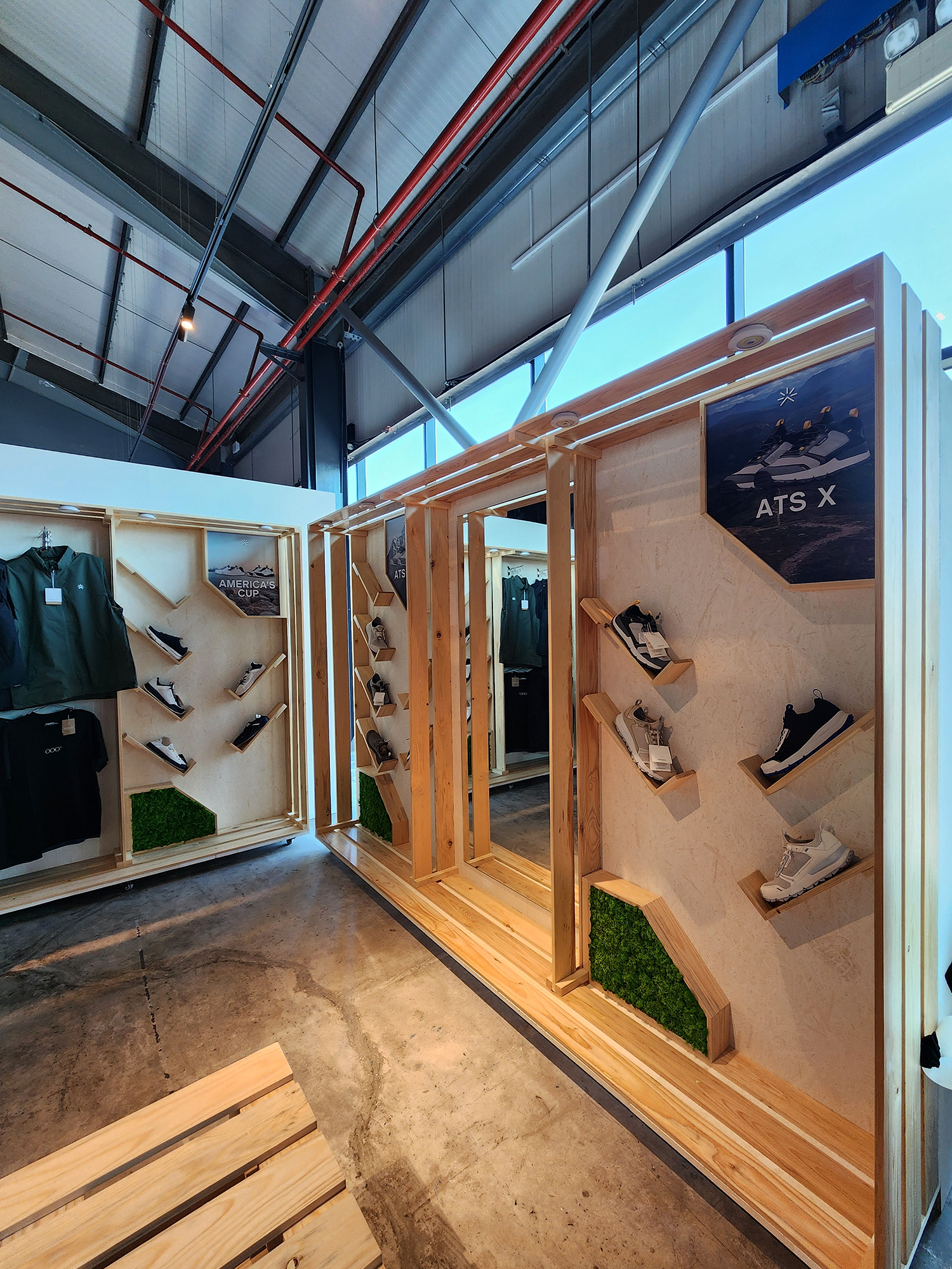 Angled footwear shelves and garment hanging areas within a custom retail display.