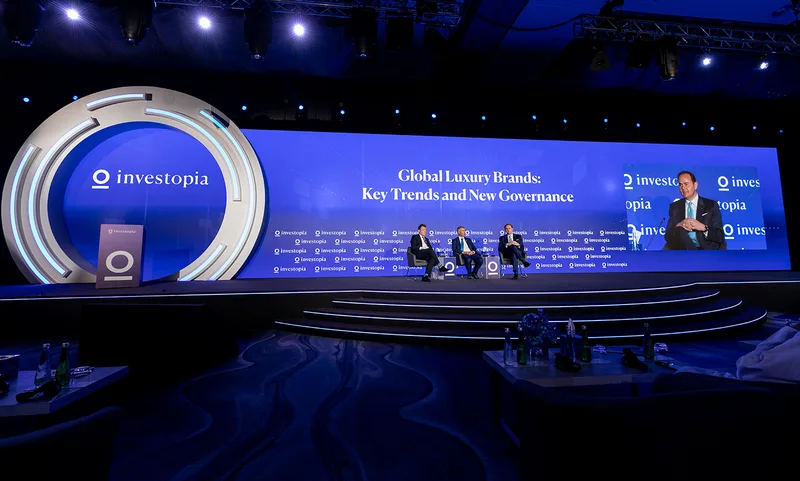 Custom circular stage fascia and stepped access beneath the Investopia presentation backdrop.
