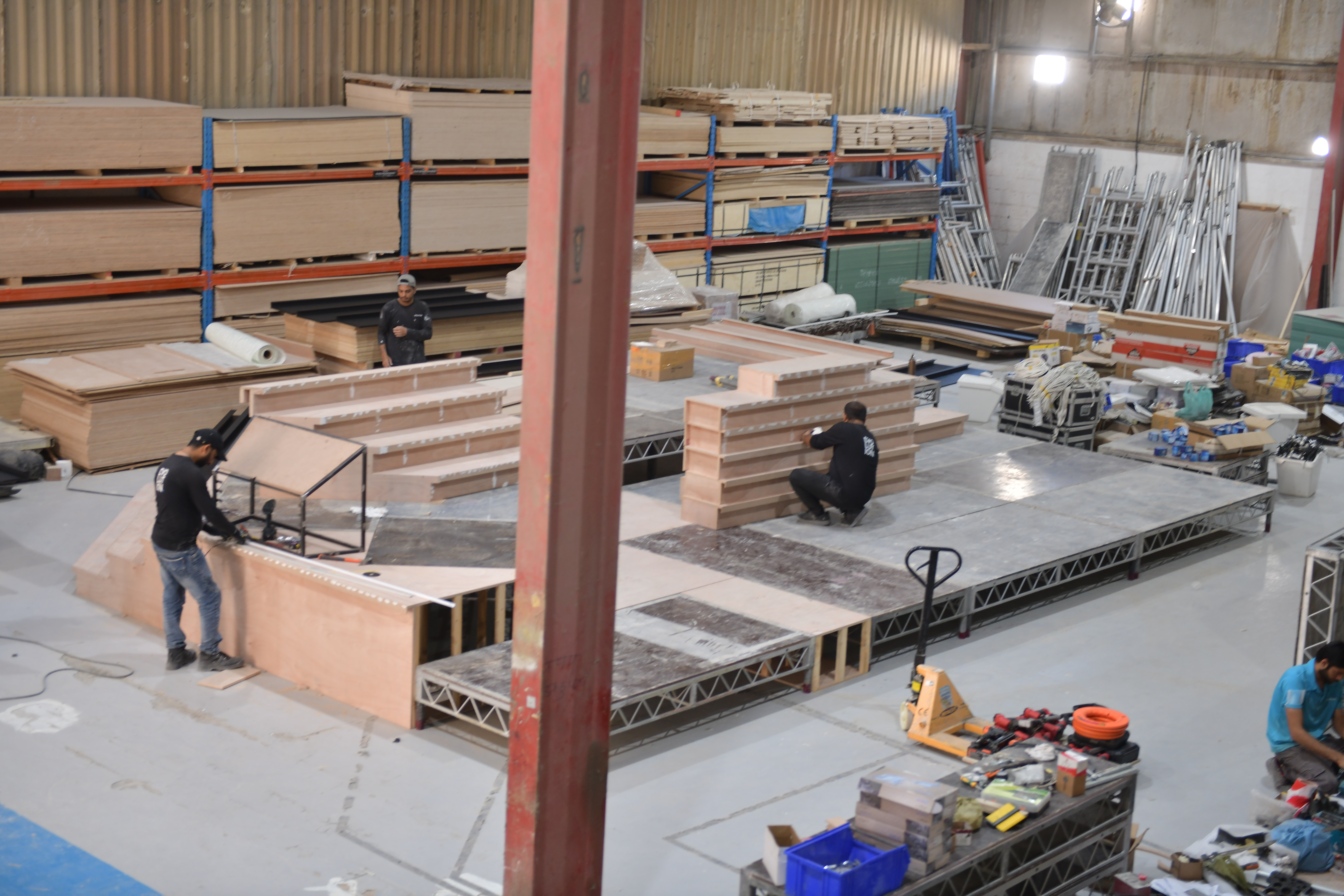Fabrication team checking numbered scenic modules before final assembly and finishing.
