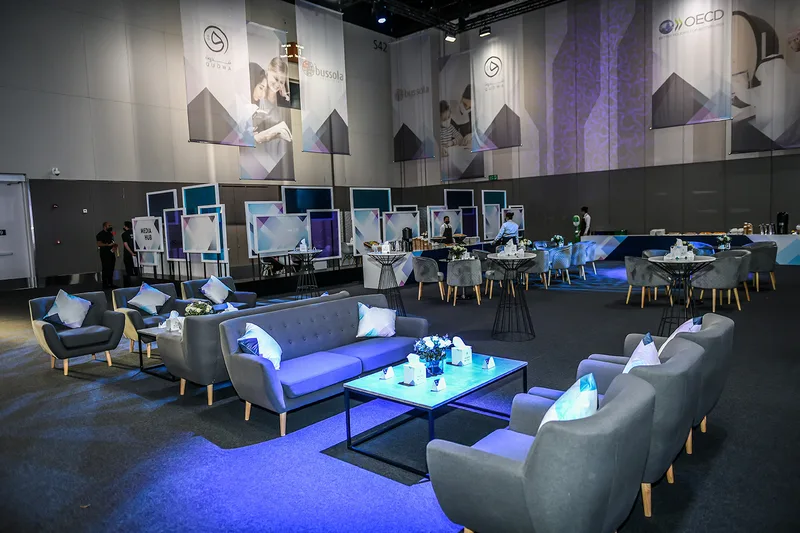 Branded lounge structures and seating elements within the temporary forum environment.