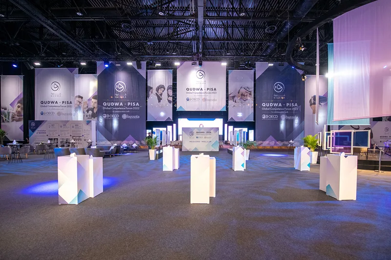Complete Qudwa–PISA forum scenery combining integrated displays, partitions, illuminated features and lounge structures.