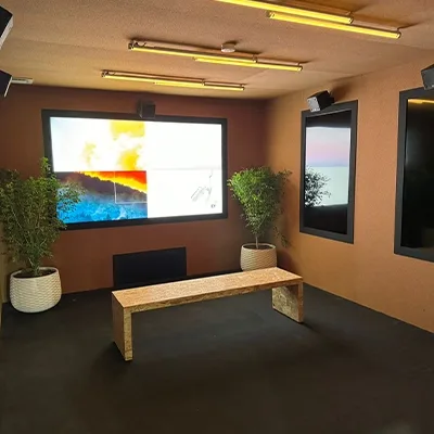 Custom fabricated immersive room with multiple digital screens and dark scenic wall finishes for EY COP28.