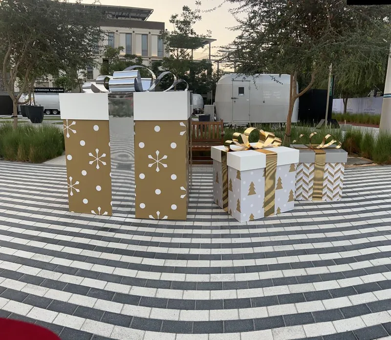 Oversized Christmas presents refurbished with dimensional bows and contrasting scenic graphics