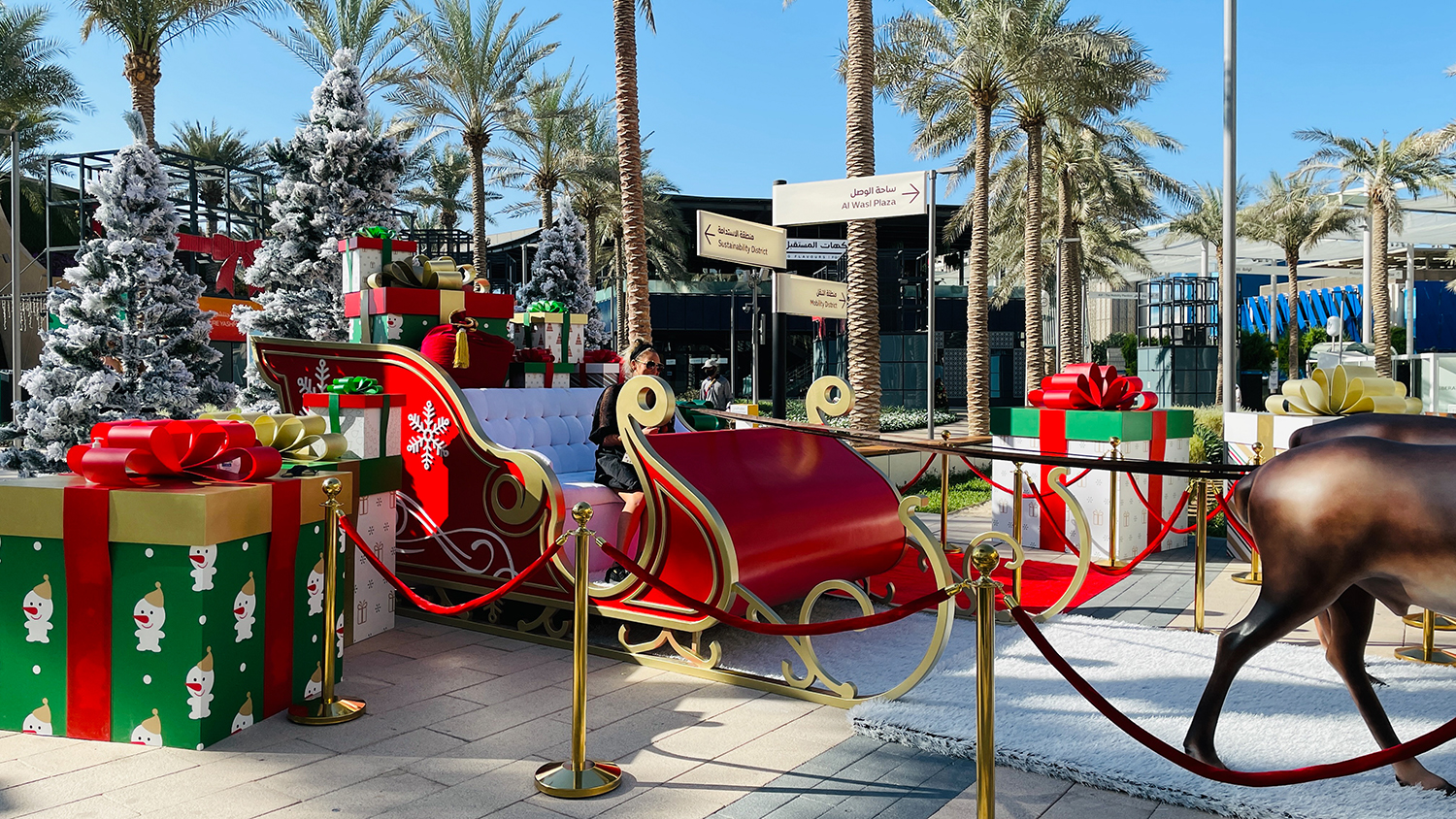 Decorative sleigh installation with oversized presents forming part of the festive scenic environment.