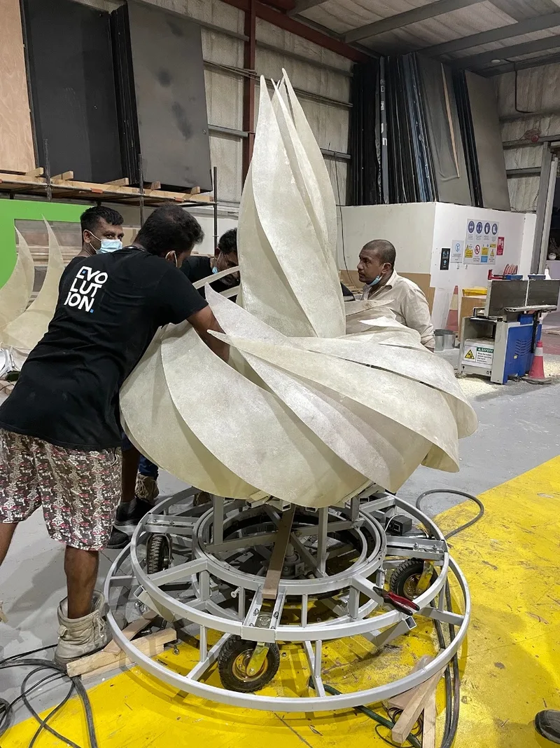 Workshop assembly of large fabric petals around the flower’s internal mechanism.