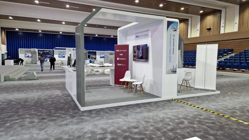 Freestanding branded totem positioned inside the back-to-back exhibition booth arrangement.