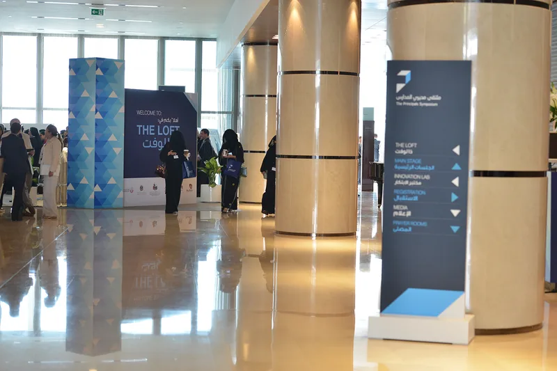 Freestanding directional sign guiding movement between symposium workshop environments.