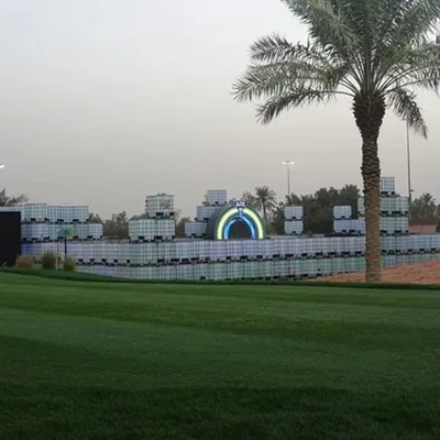 Sunset view of modular IBC scenic walls surrounding the interactive putting installation.