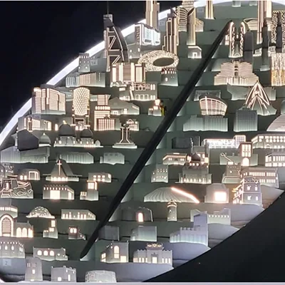 Illuminated architectural replicas rising in synchronisation from the central stage feature.