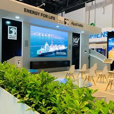 ADNOC branded scenic architecture combining painted MDF walls, graphics and digital presentation displays