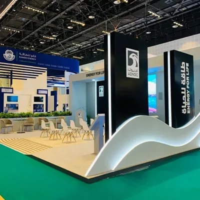 Custom MDF exhibition construction with bilingual ADNOC branding and integrated LED display technology