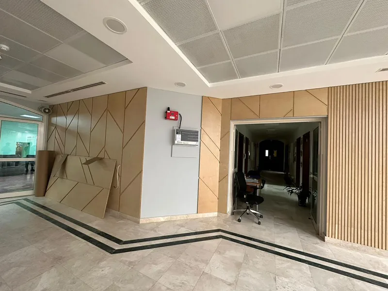 Slotted wall panel system with geometric detailing across an Abu Dhabi school interior.