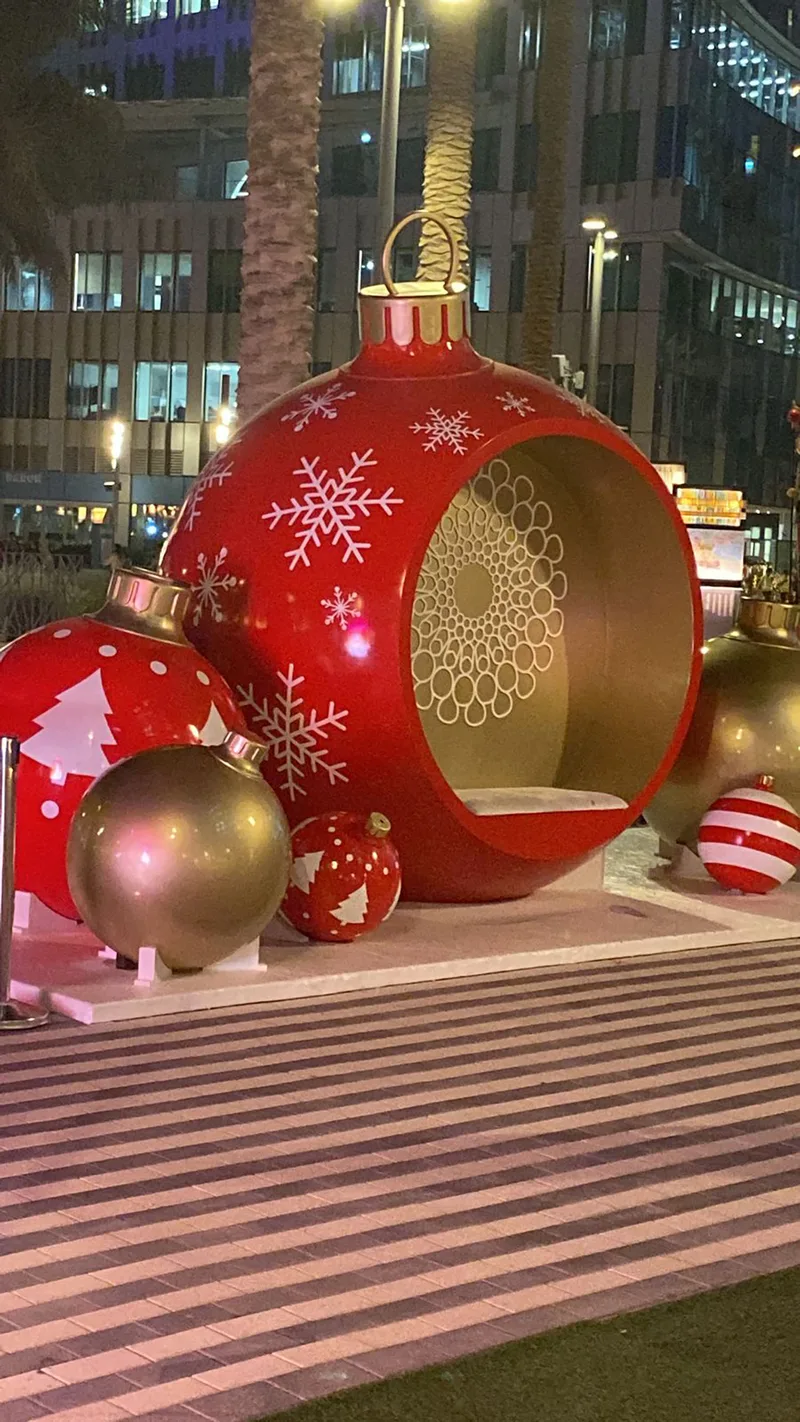 Refurbished giant Christmas bauble seating pod surrounded by decorative ornament props.