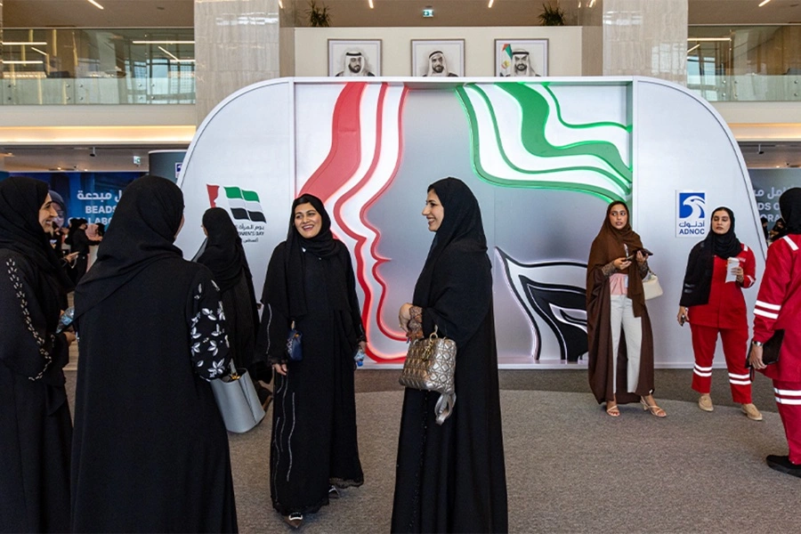 Curved reception counter positioned before the Emirati Women’s Day scenic wall.
