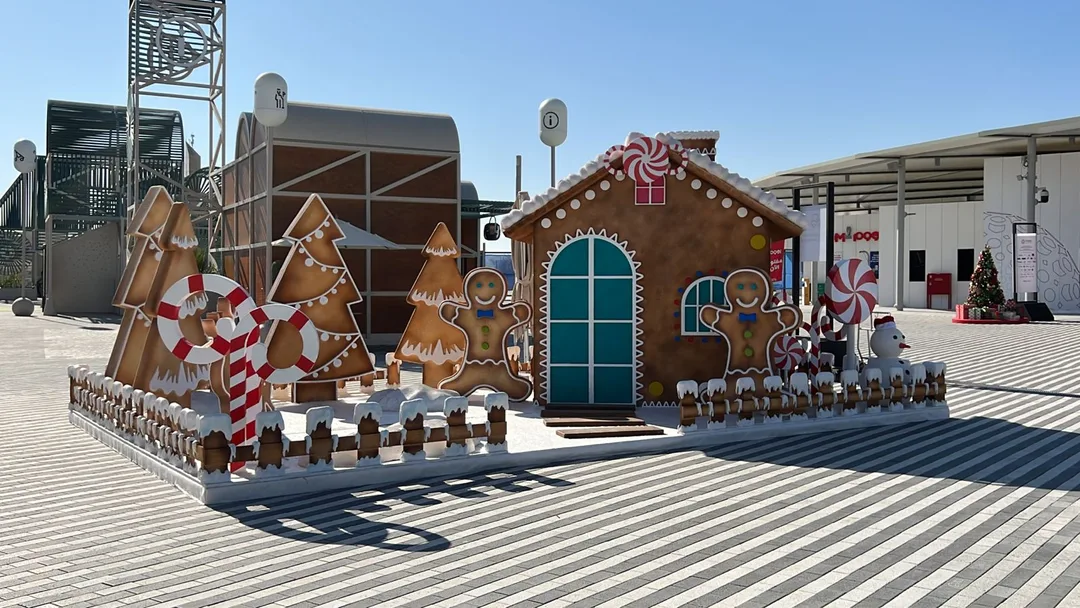Gingerbread-style Santa’s House with layered confectionery scenic detailing and oversized festive props.