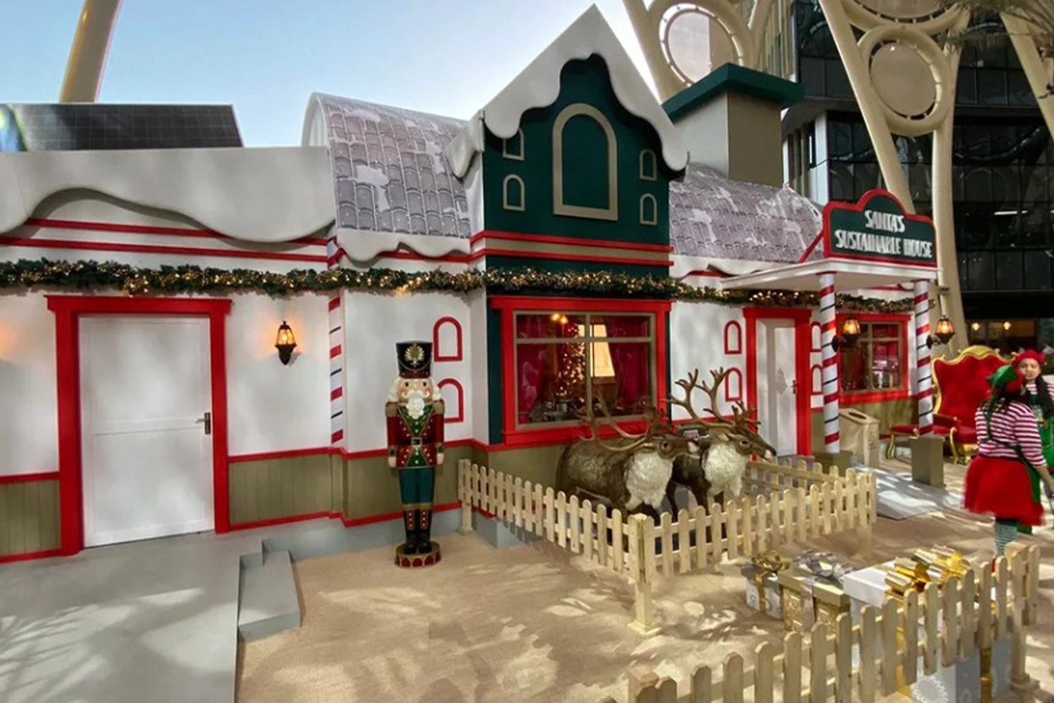 Evolution Scenic Santa’s Sustainable House with snowy roofs and candy-cane entrance columns.