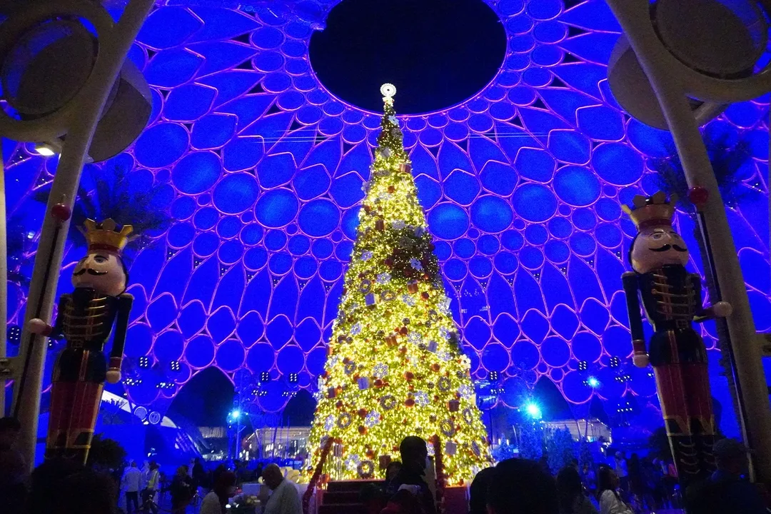 Large-scale Christmas tree surrounded by fabricated winter scenic elements at Al Wasl Plaza.