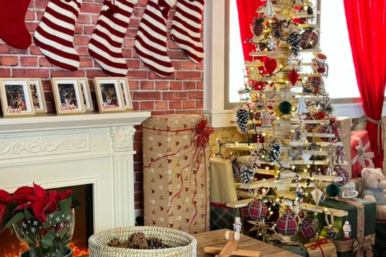 Scenic Christmas tree, wrapped presents and fireplace installation inside the temporary house.