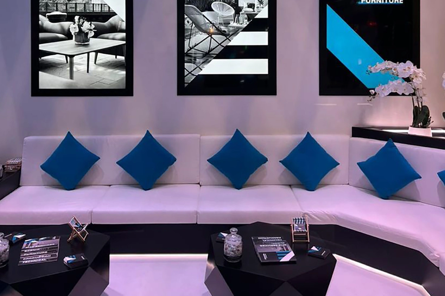 Suspended blue fabric ceiling elements supported by metal rods above the exhibition lounge.