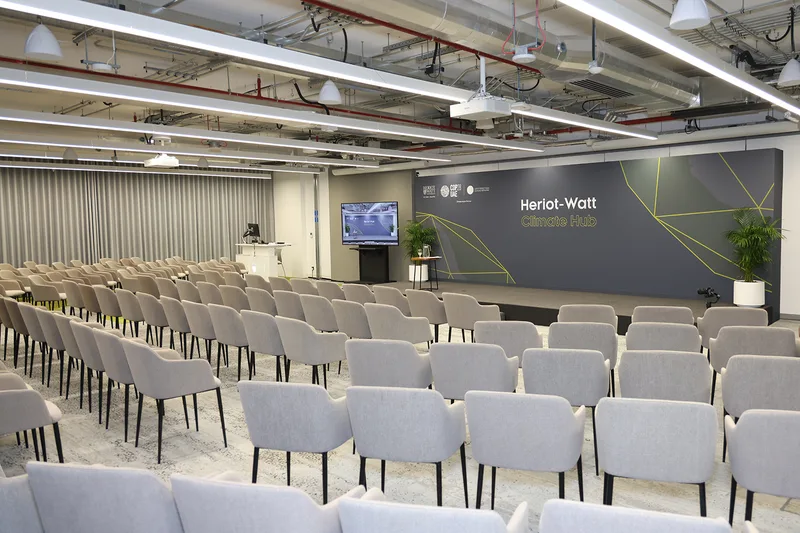 Evolution Scenic carpeted plywood stage with printed fabric backdrop at Heriot-Watt Climate Hub.