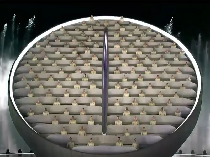 Illuminated architectural replicas rising in synchronisation from the central stage feature.