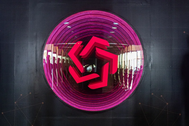 Evolution Scenic circular illuminated entrance feature within the branded exhibition environment.