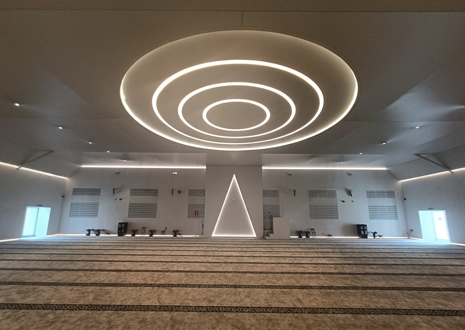 Evolution Scenic illuminated triangular mihrab within the completed prayer environment.