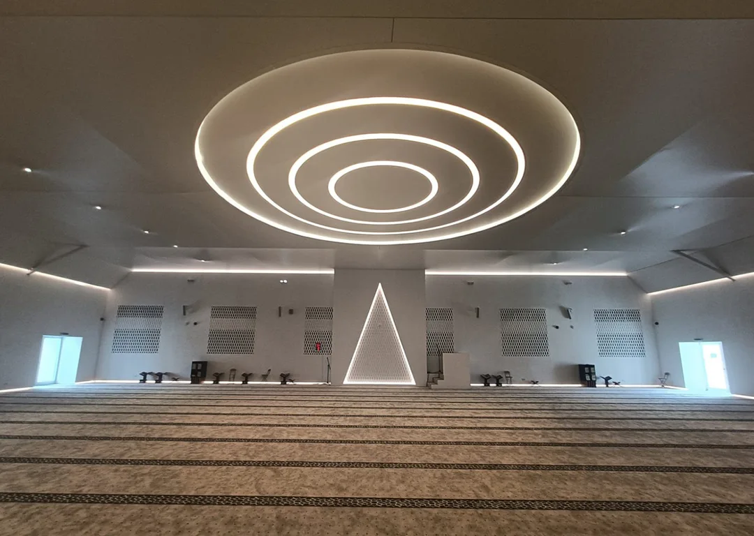 Evolution Scenic illuminated triangular mihrab within the completed prayer environment.