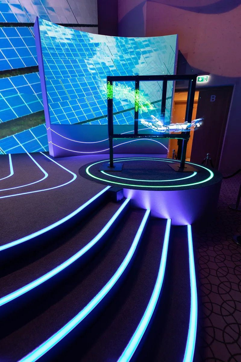 Conference stage with carpeted deck, LED strips and illuminated lightbox fascia.