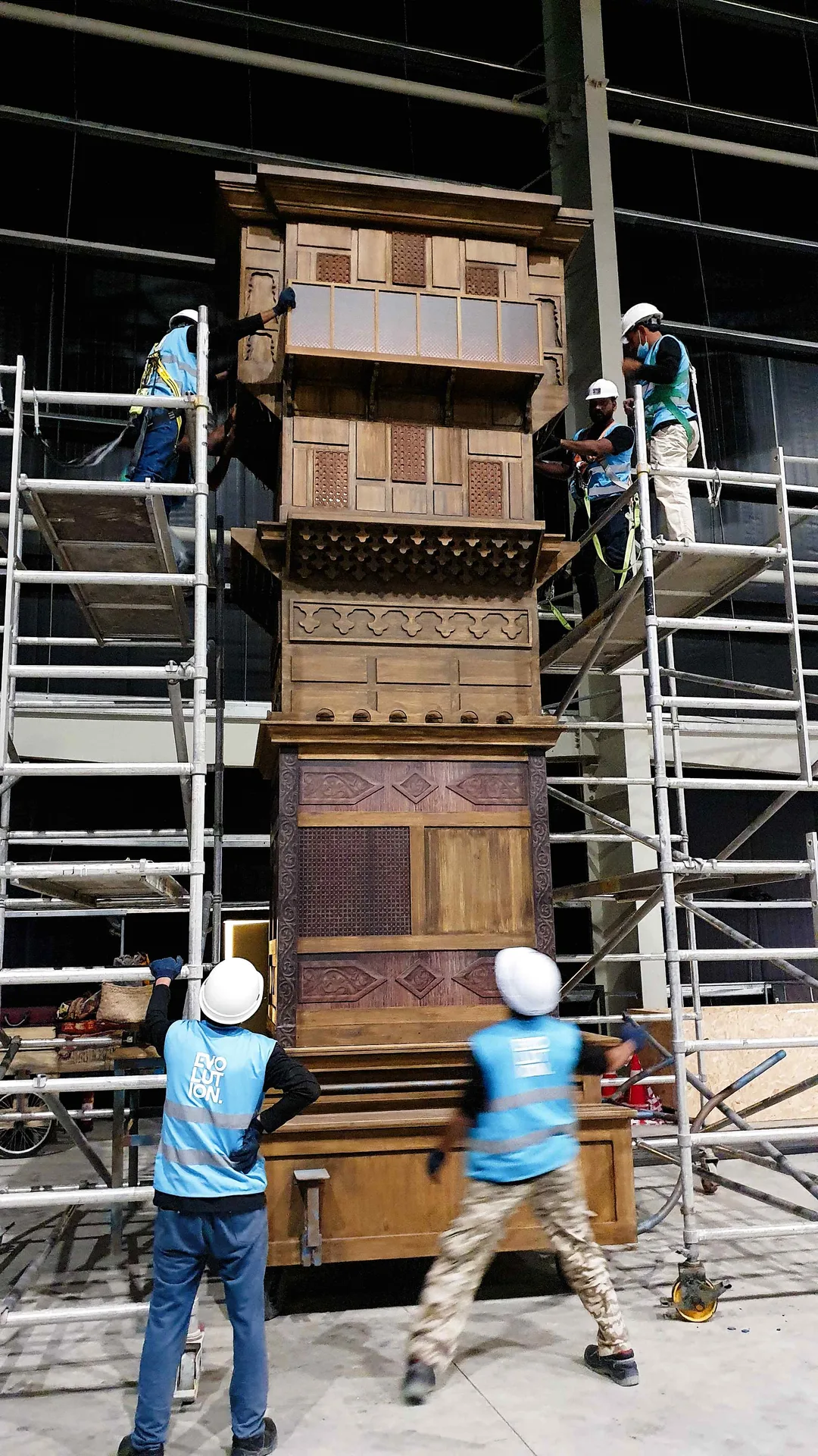 Installer using maintenance hatch during assembly of large scenic structure