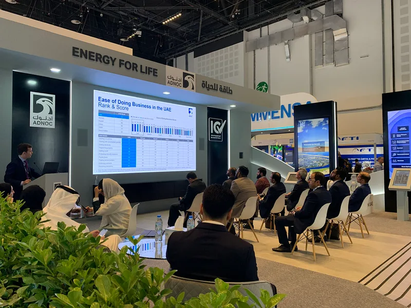 MDF scenic cladding and black architectural structures surrounding integrated digital screens at ADIPEC 2022